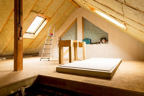 Unfertiger Dachboden mit Dämmung und Werkzeug